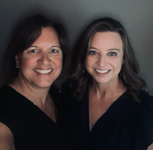 Two women smiling at the camera, representing Oklahoma Yoga.