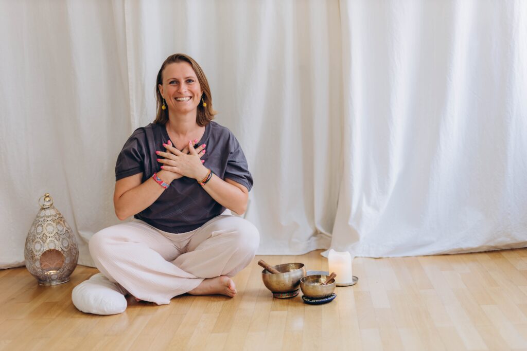 Woman smiling with hands over heart during a gratitude yoga practice at The Yoga Spa