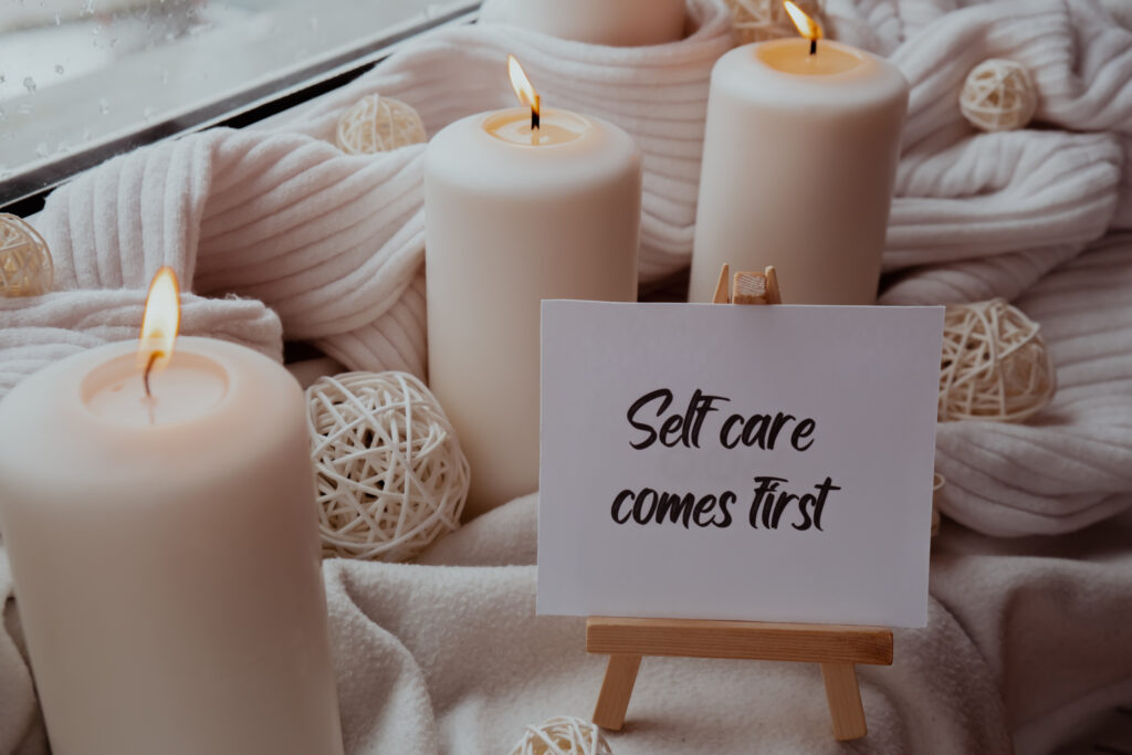 Self-love yoga self-care candle display with “Self care comes first” sign