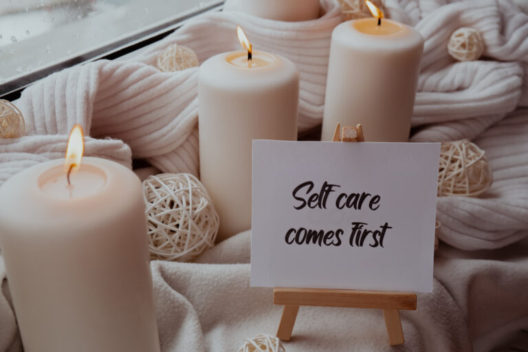 Self-love yoga self-care candle display with “Self care comes first” sign